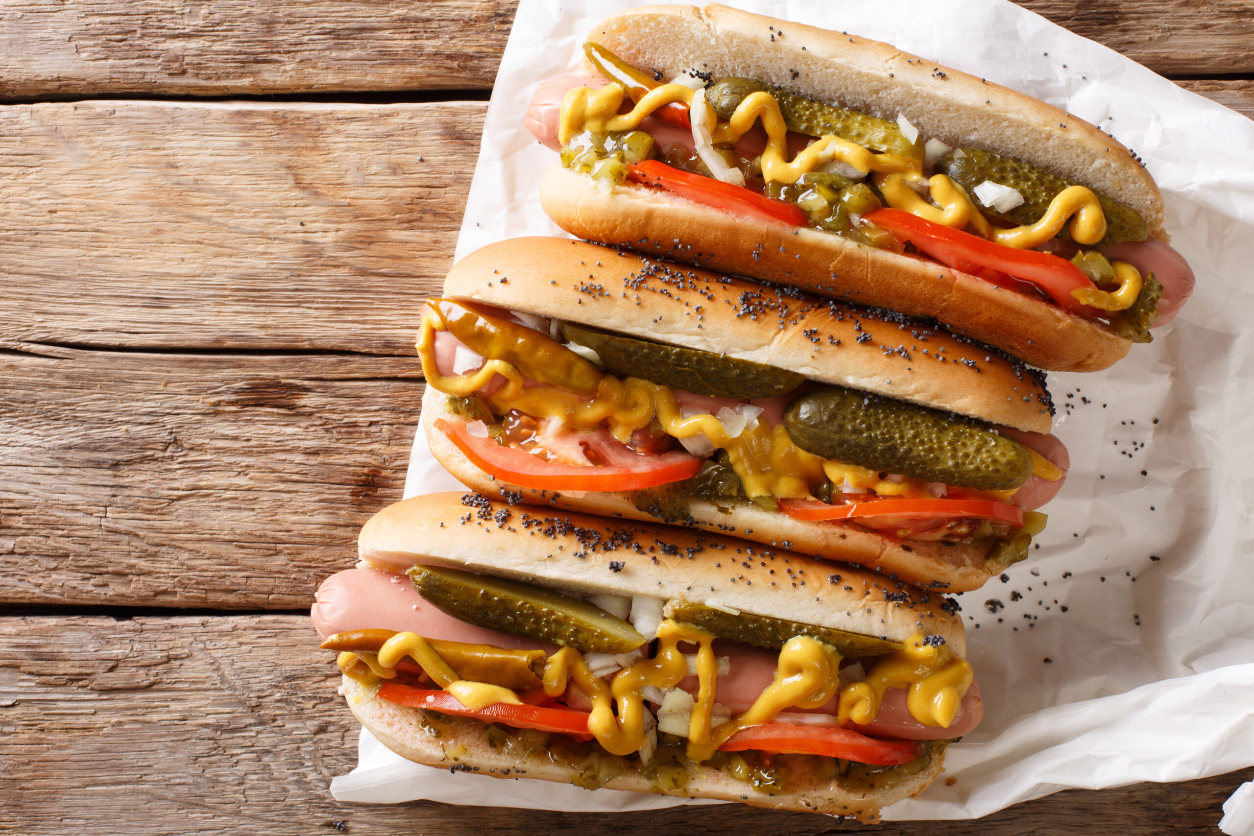 Three tasty hot dog sandwiches on a table