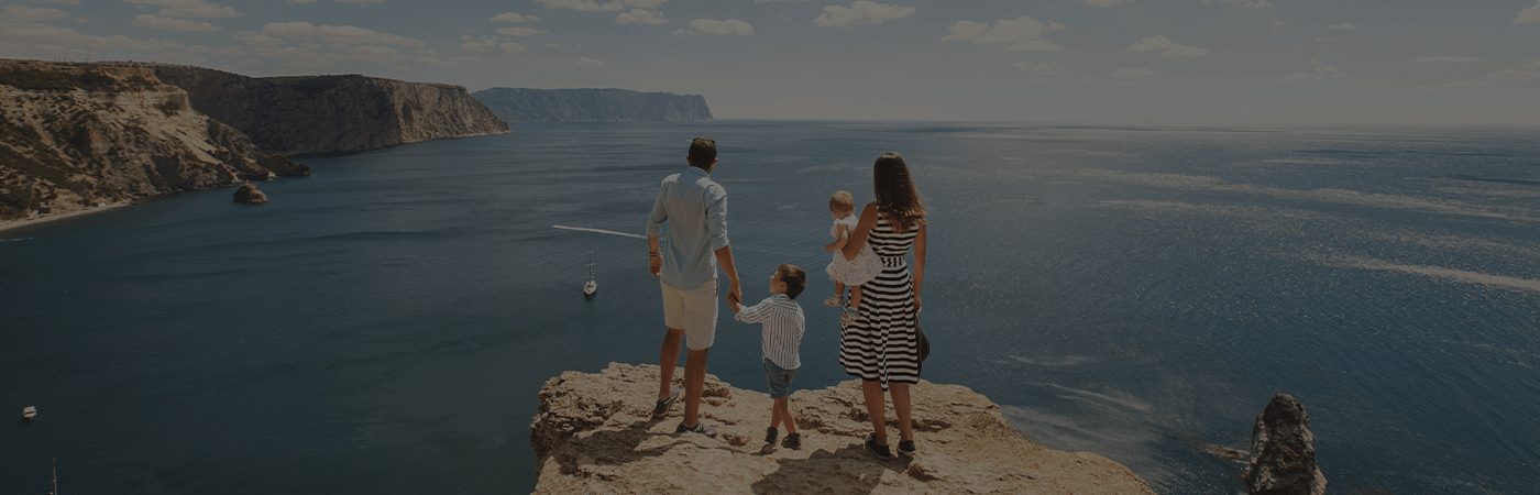 A family along with children standing at the edge of a rock