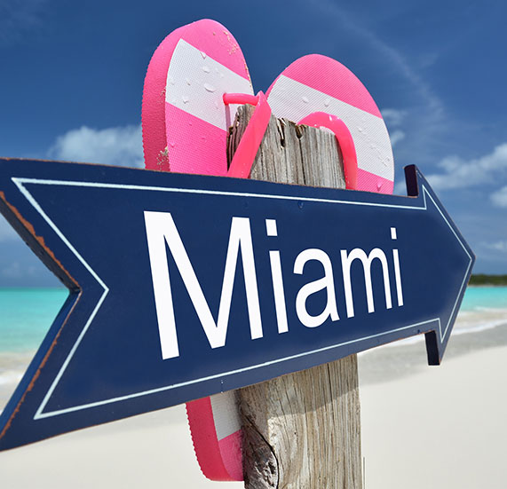 A sign board with Miami direction